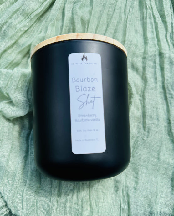 Lit Bourbon Blaze Shot soy candle with bourbon, vanilla, and strawberry notes creating a warm, cozy, and sophisticated fall ambiance.