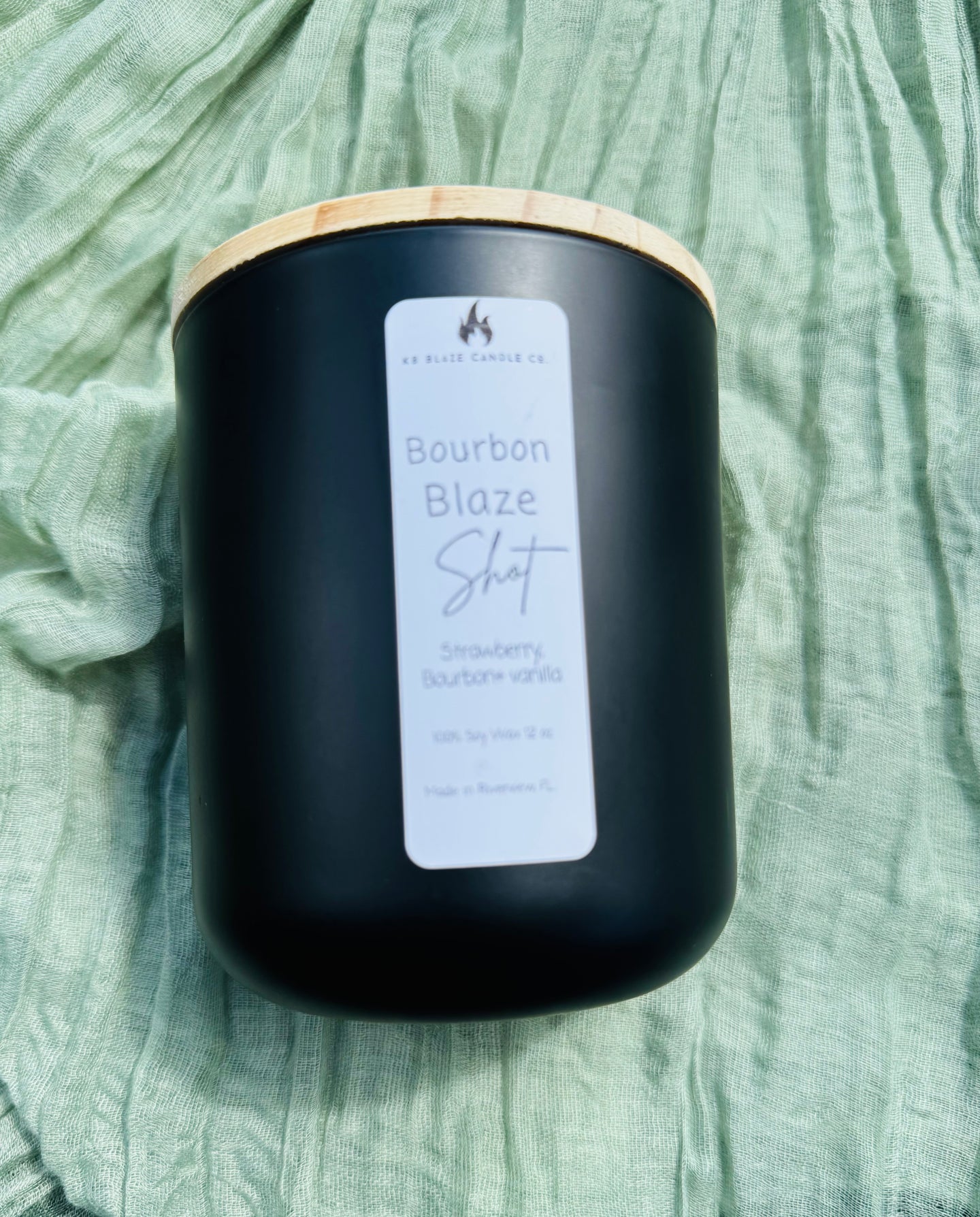 Lit Bourbon Blaze Shot soy candle with bourbon, vanilla, and strawberry notes creating a warm, cozy, and sophisticated fall ambiance.